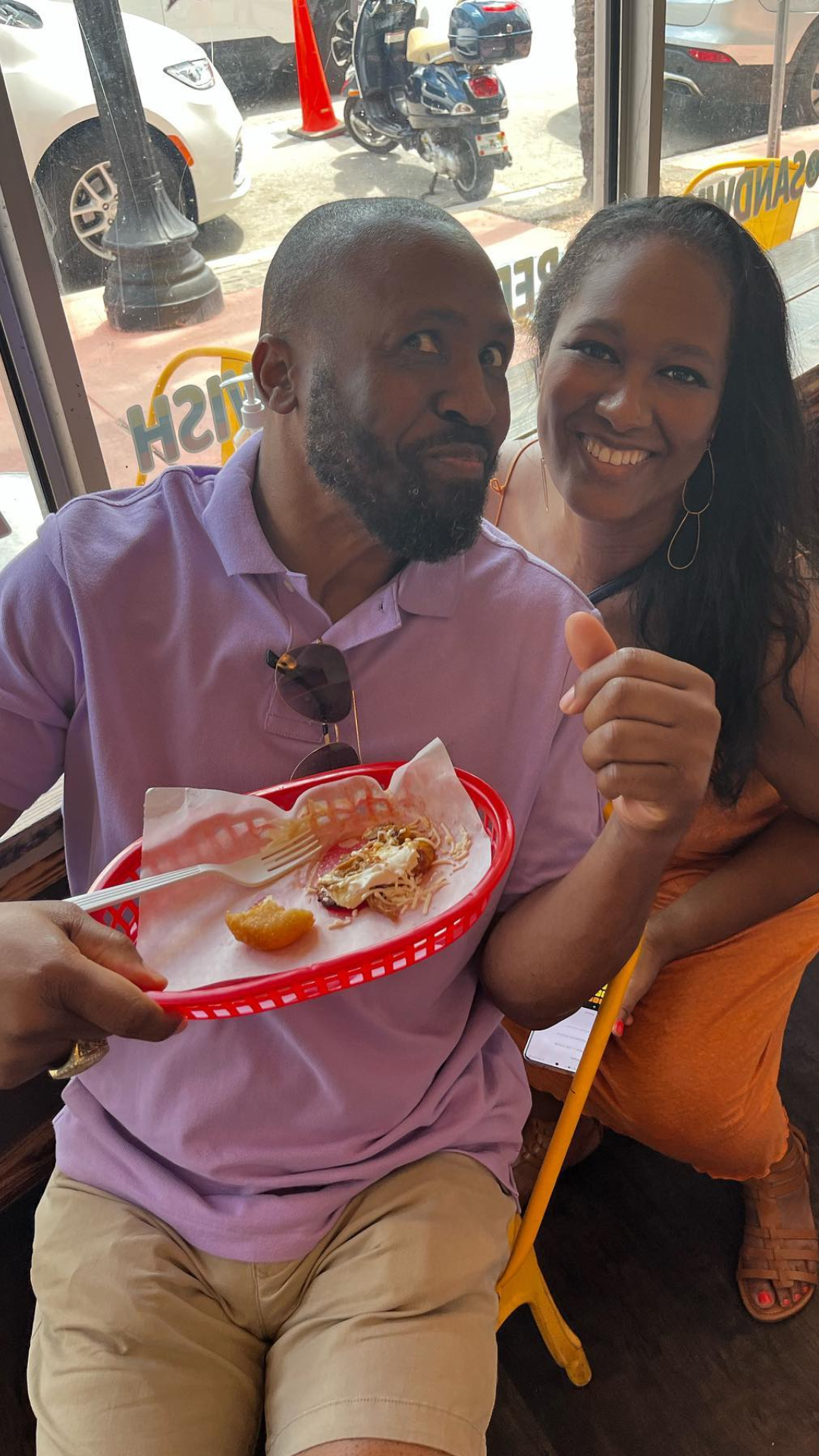 a person sitting at a table with a hot dog