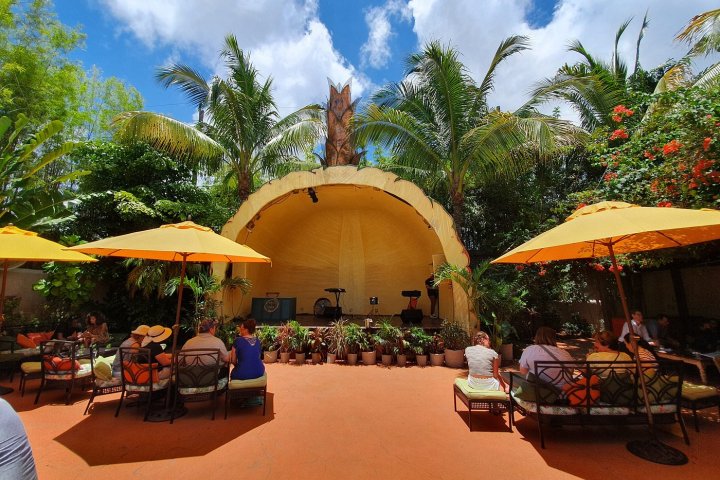 a group of people sitting at a table with an umbrella