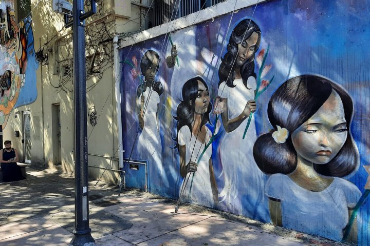 a group of people standing next to a graffiti covered wall
