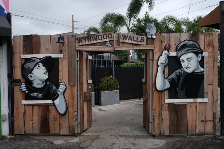 a statue of a person with graffiti on the side of a building