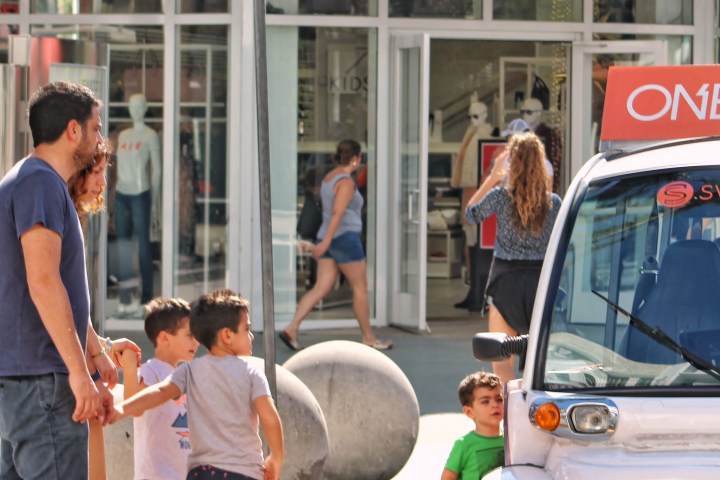 a group of people standing in front of a car